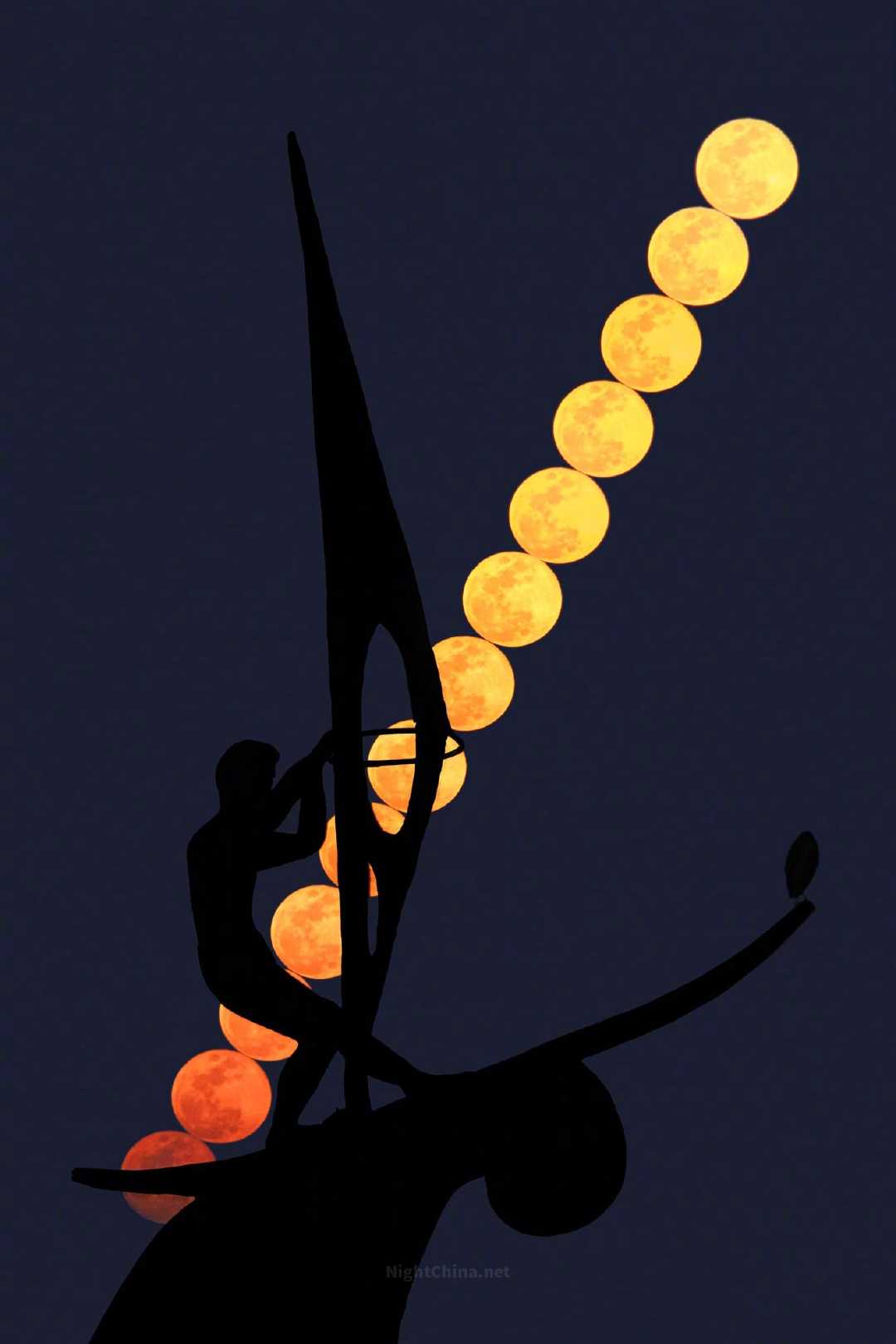 当将盈的明月沿轨而行，清冷的引力便在江畔无声弥漫。在那交错上升的建筑框架下，孤帆