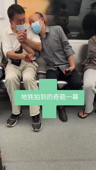 地铁上拍到的奇葩一幕。
两位中年大叔坐在一起，其中身穿灰衬衣的谢顶大叔竟然还和旁