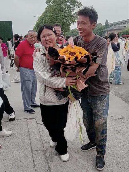 6月7日，安徽阜阳颍上二中考点外，一位浑身沾满泥巴、手捧向日葵的父亲，令无数人动