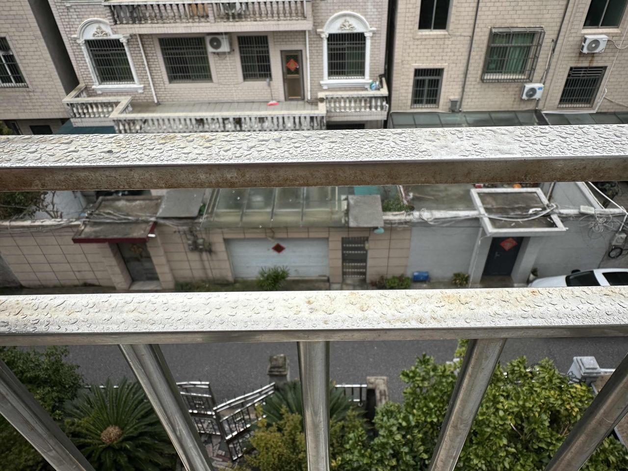 大雾天气，很潮湿。
阳台花架栏杆像淋雨似的。
都快9:00了，雾还没散去，虽有微