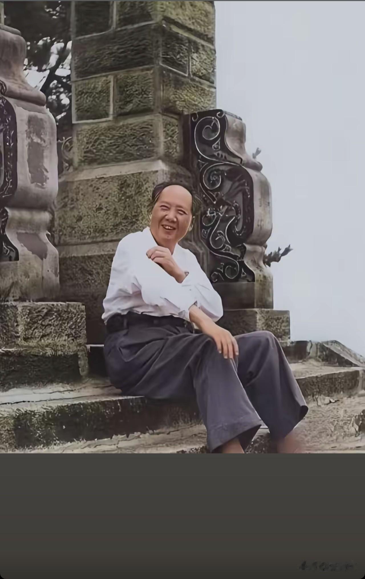 毛主席静坐在石阶上，笑容朴实又格外亲切。