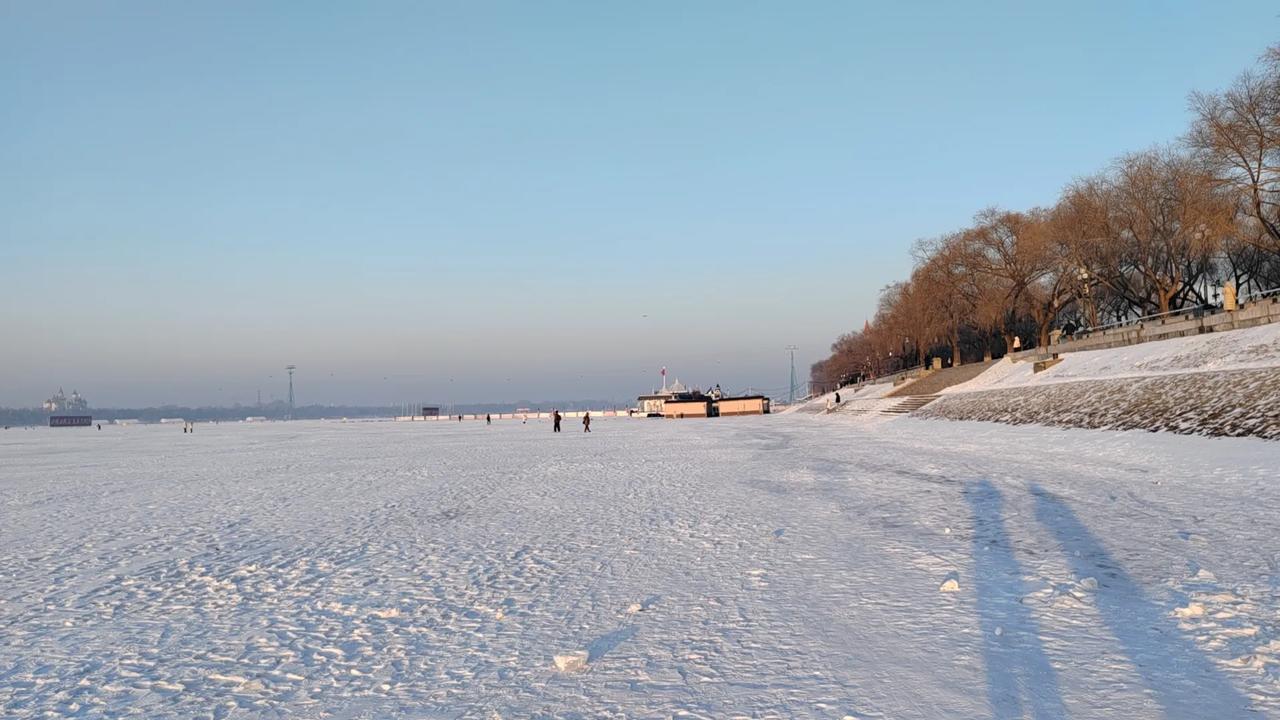 晒一下你相册里的雪景照片吧老家哈尔滨的雪景。松花江边，江面白雪覆盖，白雪之下是冰