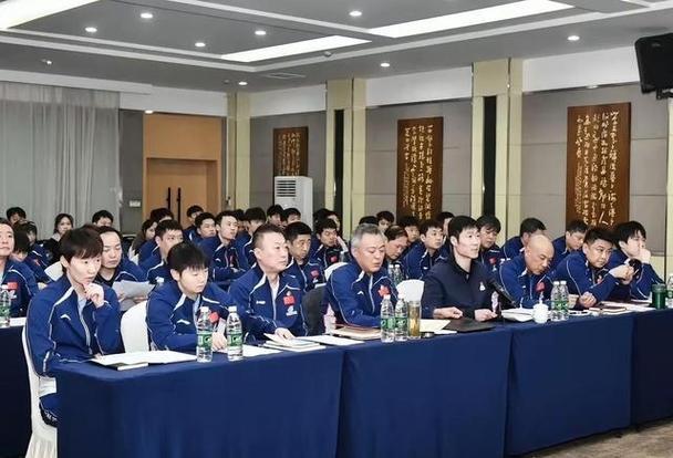 一众国乒教练员、球员出席会议同框照：乒协主席王励勤坐姿端庄，目光沉和；教练员秦志