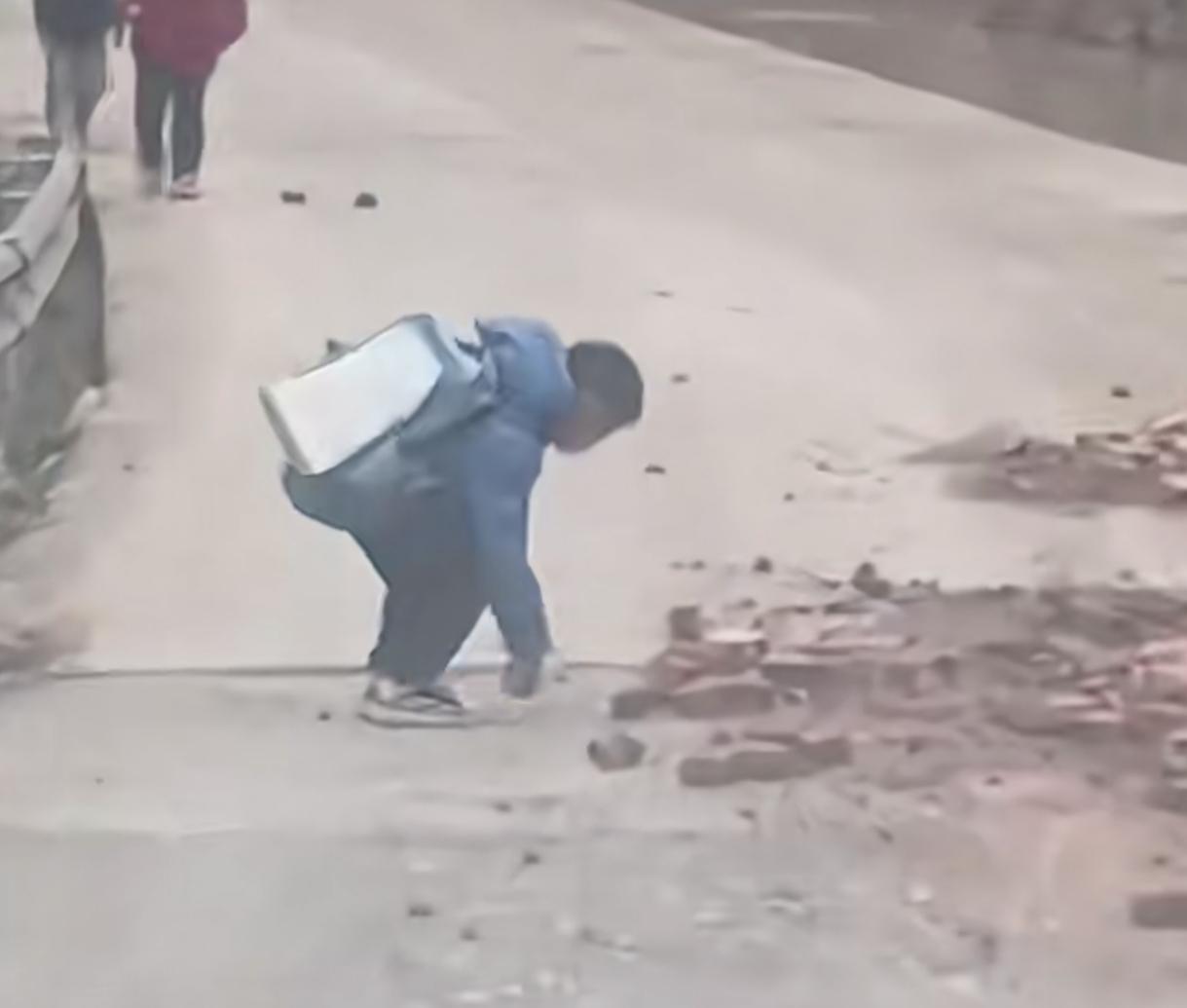 双向奔赴的“误解”
司机停车礼让小孩过路，
小男孩以为碎砖头挡路，立马上前捡起砖