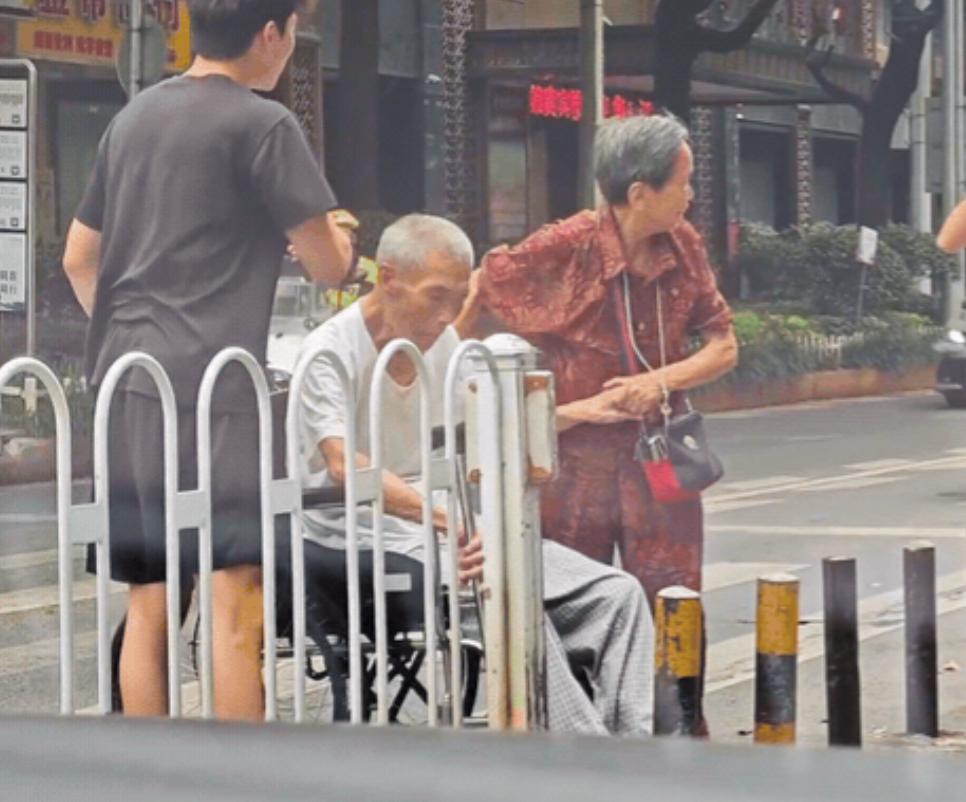 “太暖心了！”湖南街头，一老奶奶推着坐轮椅的老伴过马路时，被狭窄的隔离柱“卡”住