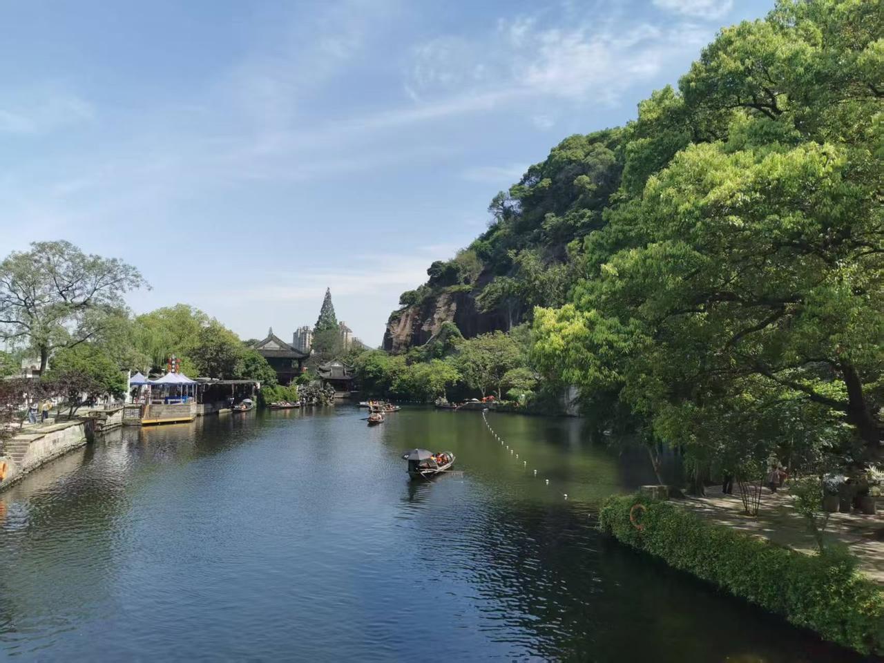 晴风拂过绍兴东湖的水面，漾开层层温柔的涟漪。乌篷船轻轻划过碧绿的湖水，船桨拨水的