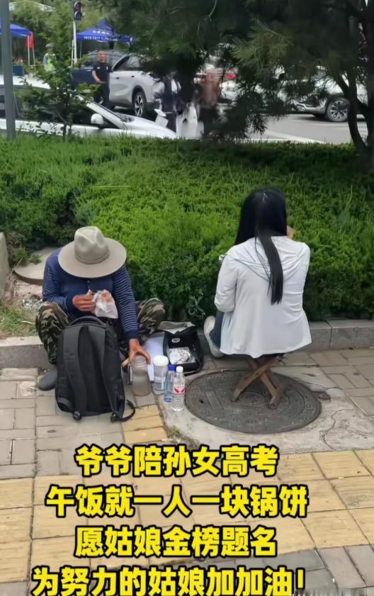 高考最后一天，一位送考家长随手拍的，考场外的马路牙子上，爷爷陪着刚考完的孙女吃午