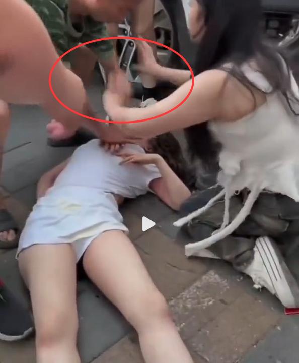 女子倒地不起，闺蜜阻止他人施救？

在视频中，一女子倒地不醒，周围围了很多人，有