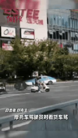 贵州贵阳，摩托车驾驶员在路上与后方货车司机发生口角，摩托车驾驶员对着货车招手，货