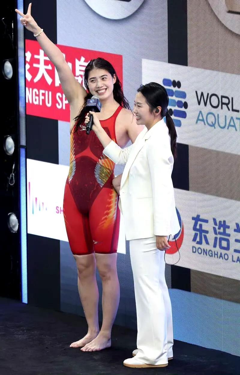 采访张雨霏的白衣服小姐姐这笑容很甜美啊，张雨霏比Y的手势也特别可爱！让看到她们的
