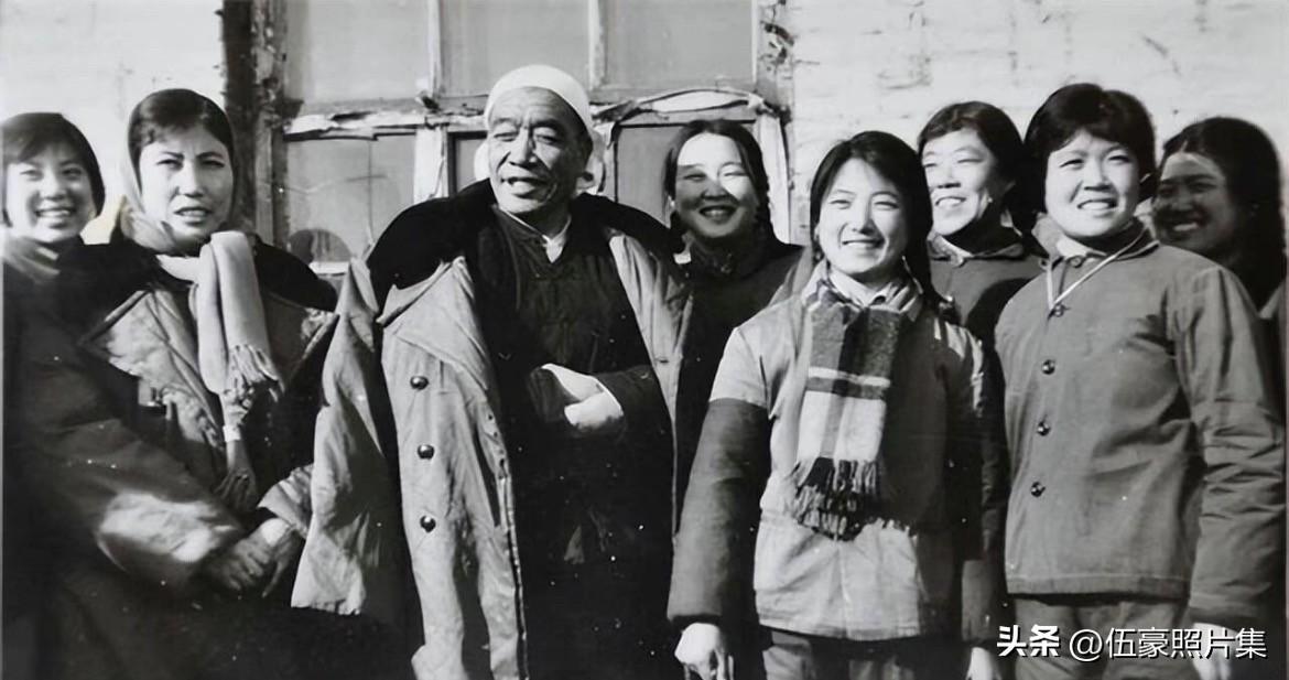 1975年，山西大寨，头戴白毛巾、身着厚棉大衣的是陈永贵，他身旁笑容灿烂的年轻女