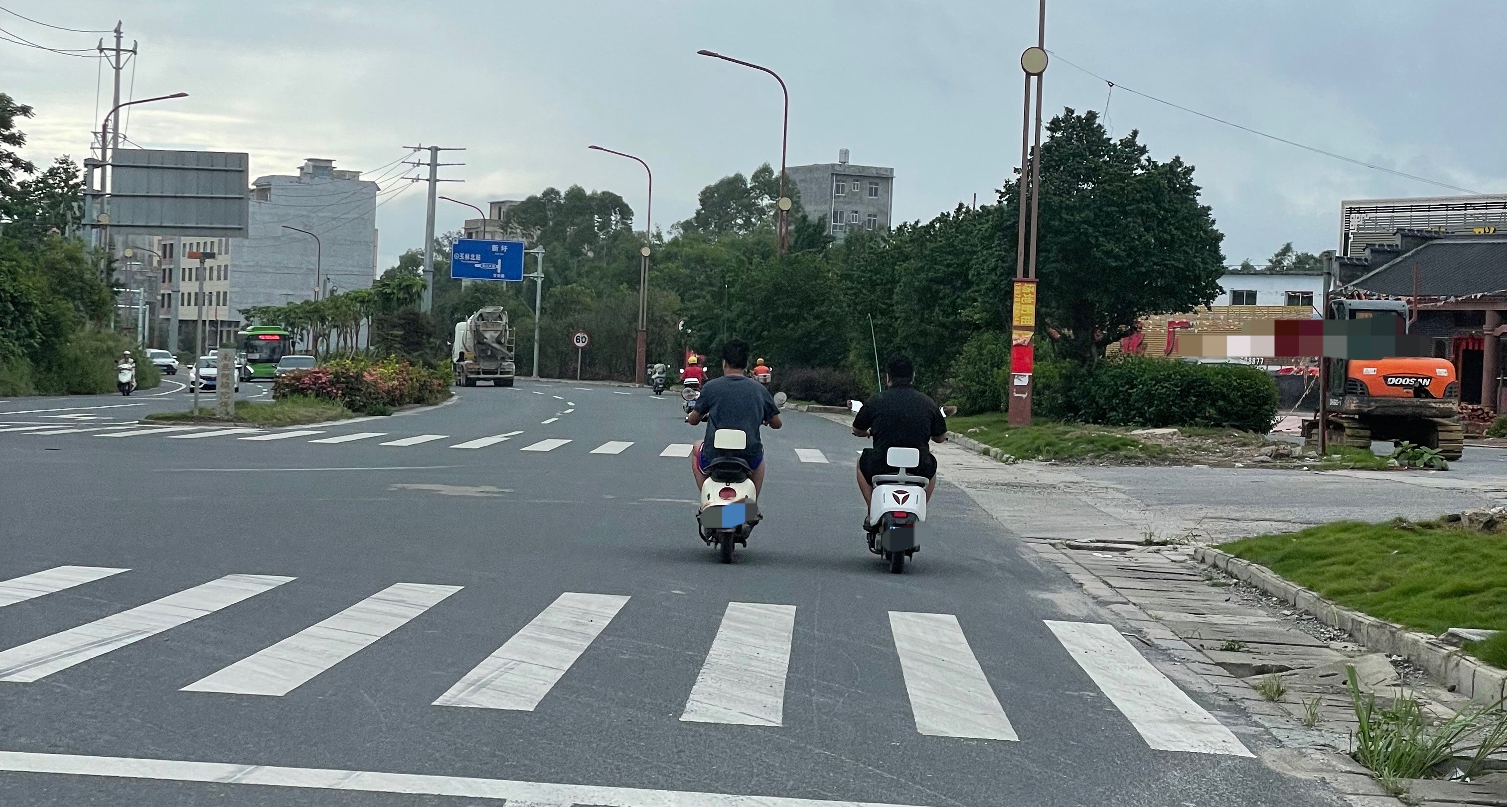 【玉林家具大街两男子并排骑电车】6月27日，玉林市北流家具大街两名青年男子一路并
