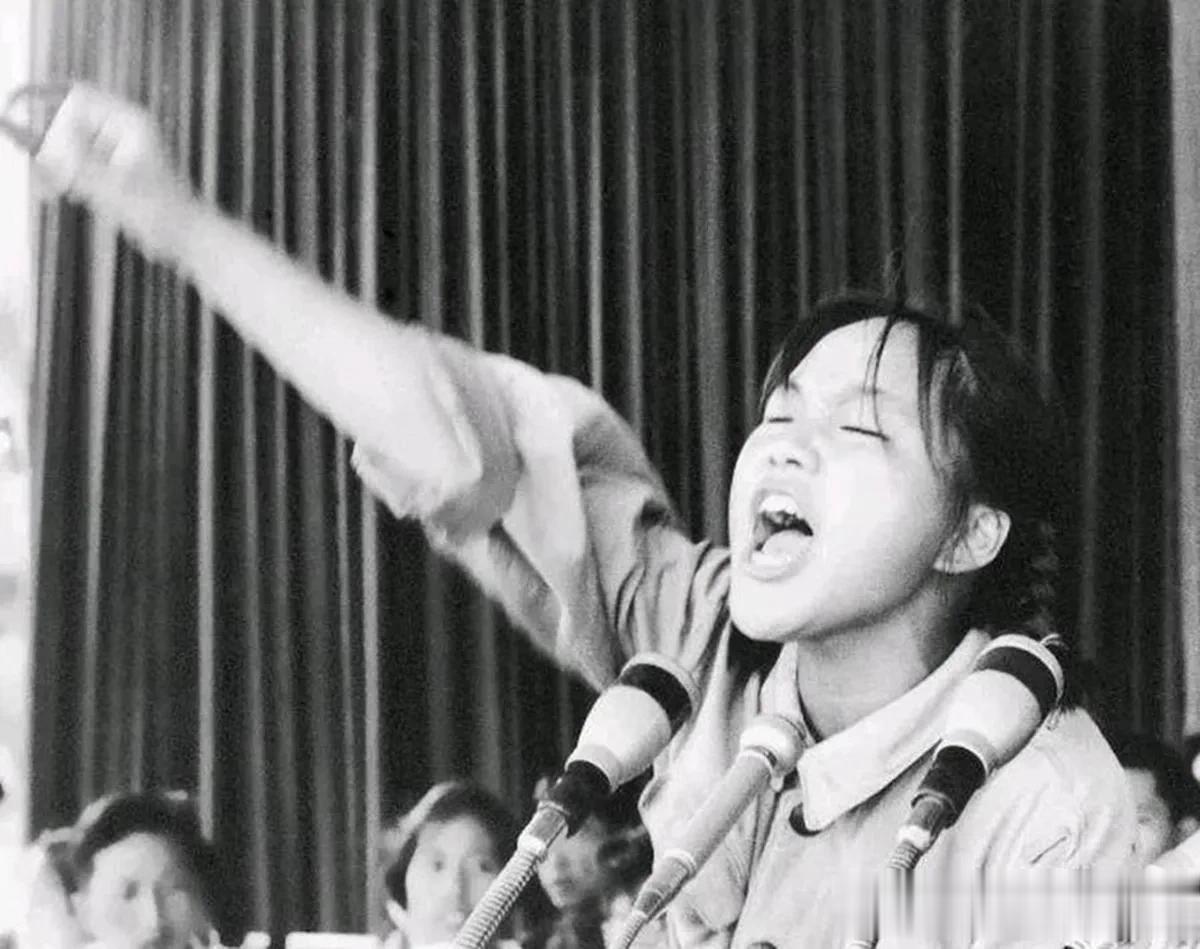 1966年，一个年轻女孩正在发表演说的一张老照片，她挥动着右臂，表情投入，隔着屏