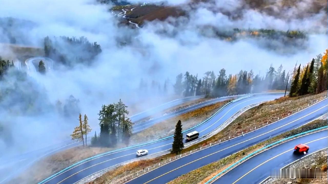 大新疆的秋天，旅游持续升温，拍下云雾中的阿禾公路，盘山公路在云雾间婉转缠绕，穿行