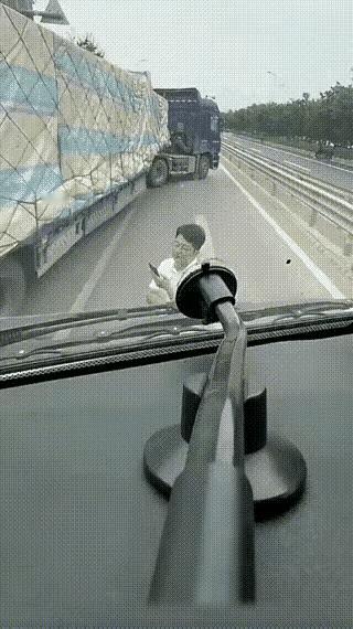小伙儿热情得欢迎大货车和他亲密接触，还多次伸出无名指对货车司机表示感谢！