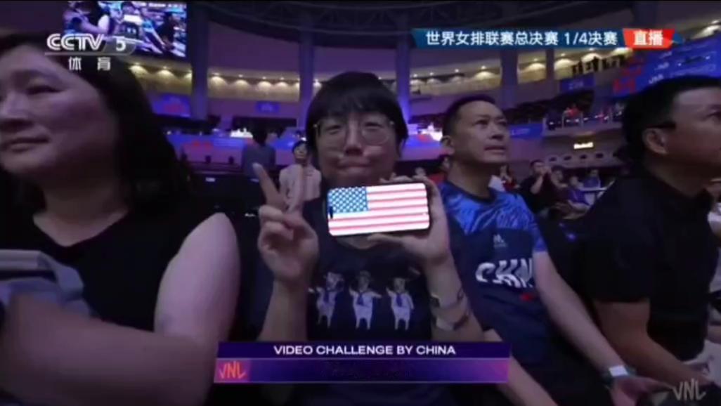 心细的几位网友，注意到了赛场上观众席里的一位女观众晃动着手机屏幕上的美国国旗。