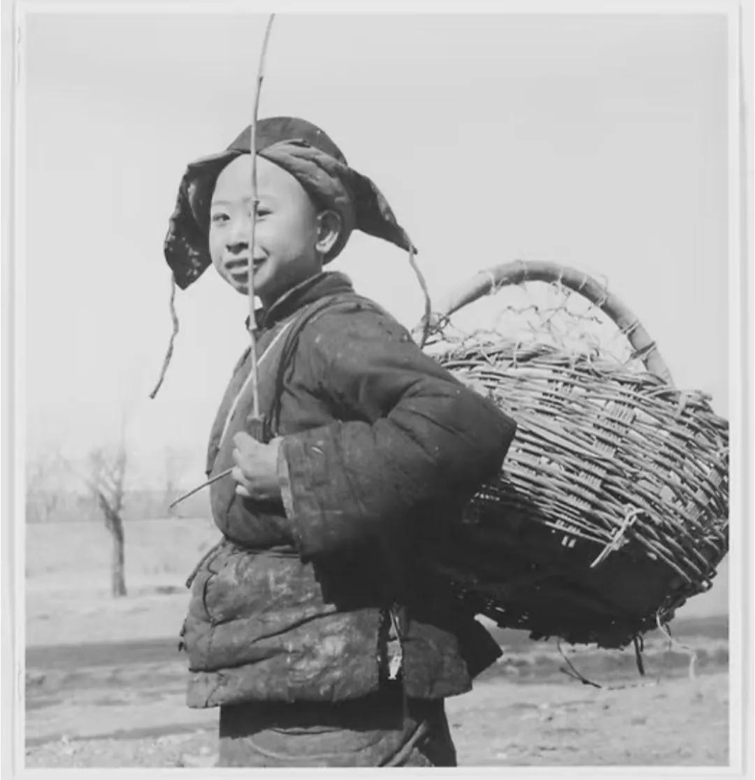 这张民国老北京照片存在争议：有人说男孩是卖豆芽的小贩，也有人说他是捡废品补贴家用