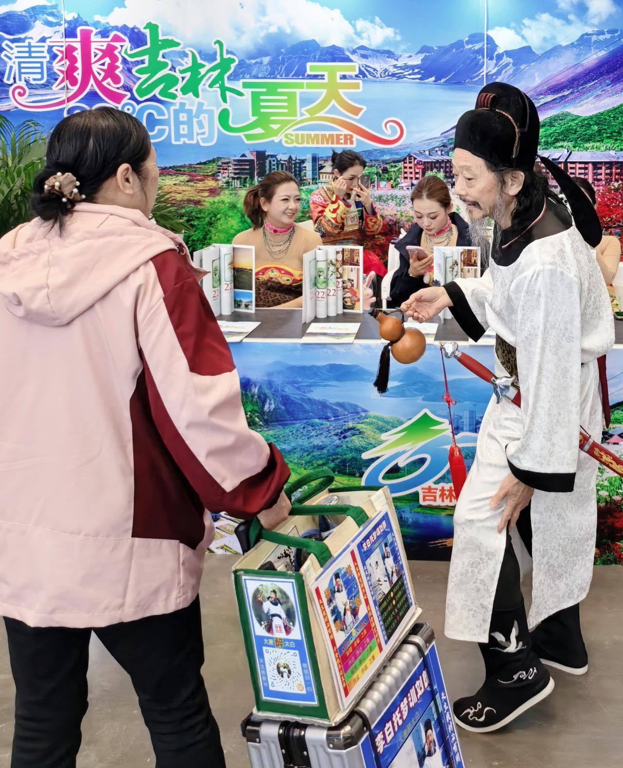 西安春季展销会上，穿汉服的“李白”正给阿姨递酒葫芦，身后是朝鲜族姑娘笑靥如花，左