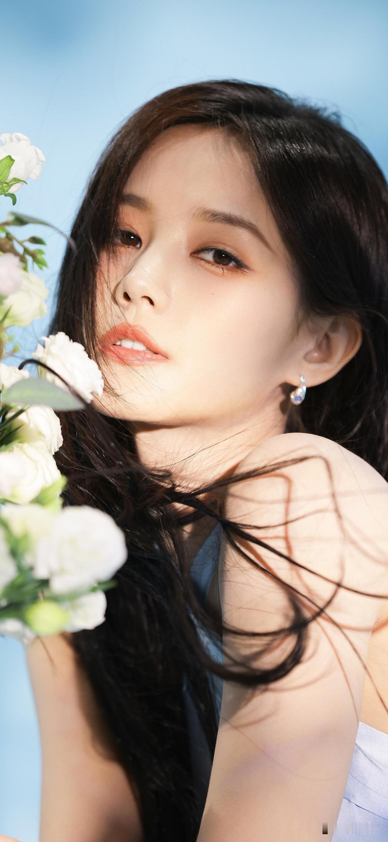 蓝天做背景时，李一桐捧着白玫瑰笑，浅蓝裙子衬得人像刚绽放的花苞，发丝飘在脸颊痒乎