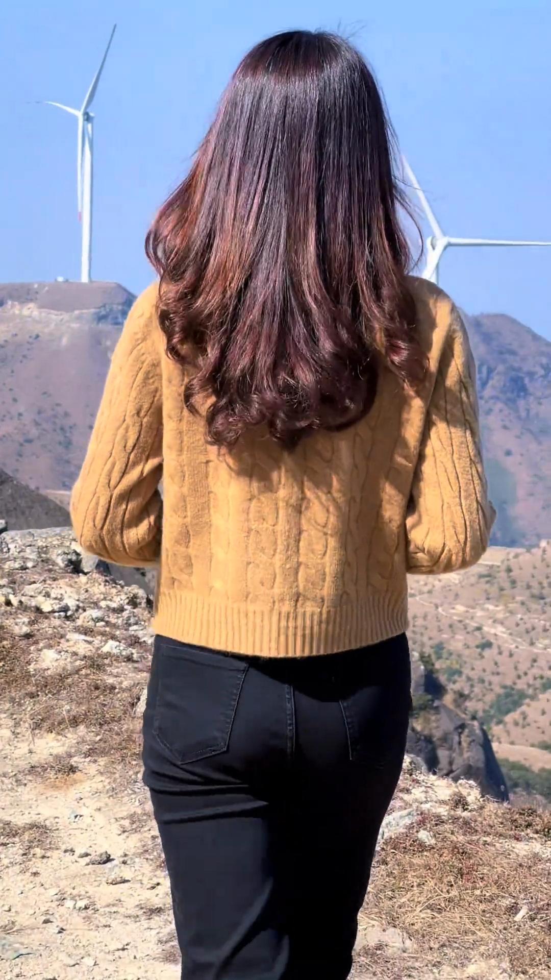 背对镜头，看风车风景。