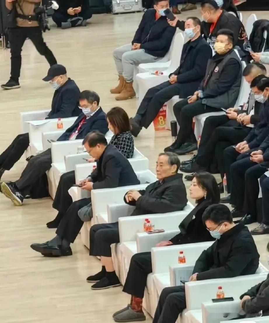 太火了！两个亿万富翁，一个穿棉鞋一个穿布鞋，正襟危坐，目不斜式！看看周围的人要么