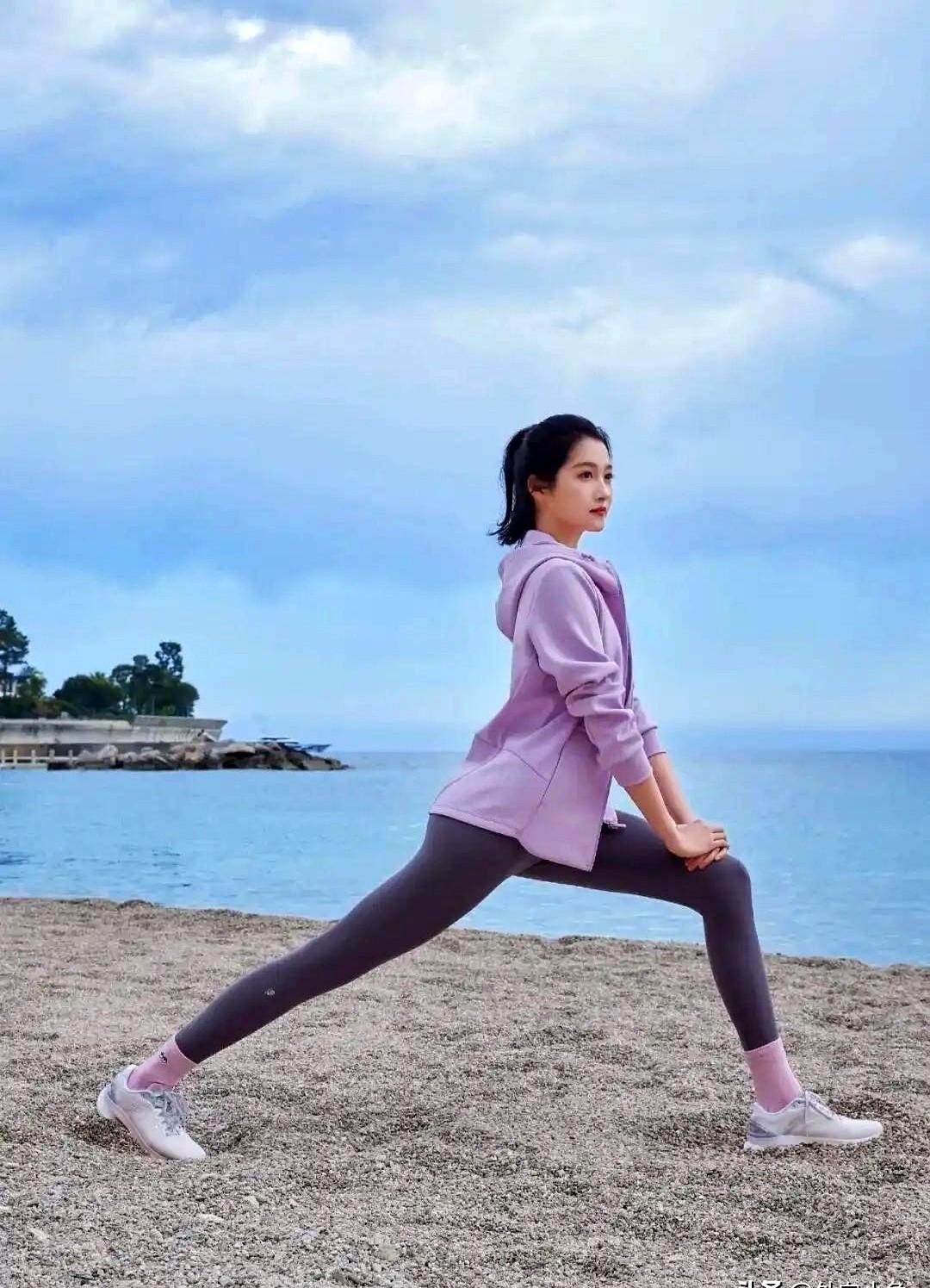 关晓彤又在海边“炫腹”了，这次是全套紫色运动装，连帽外套一脱，就剩贴身那两件。