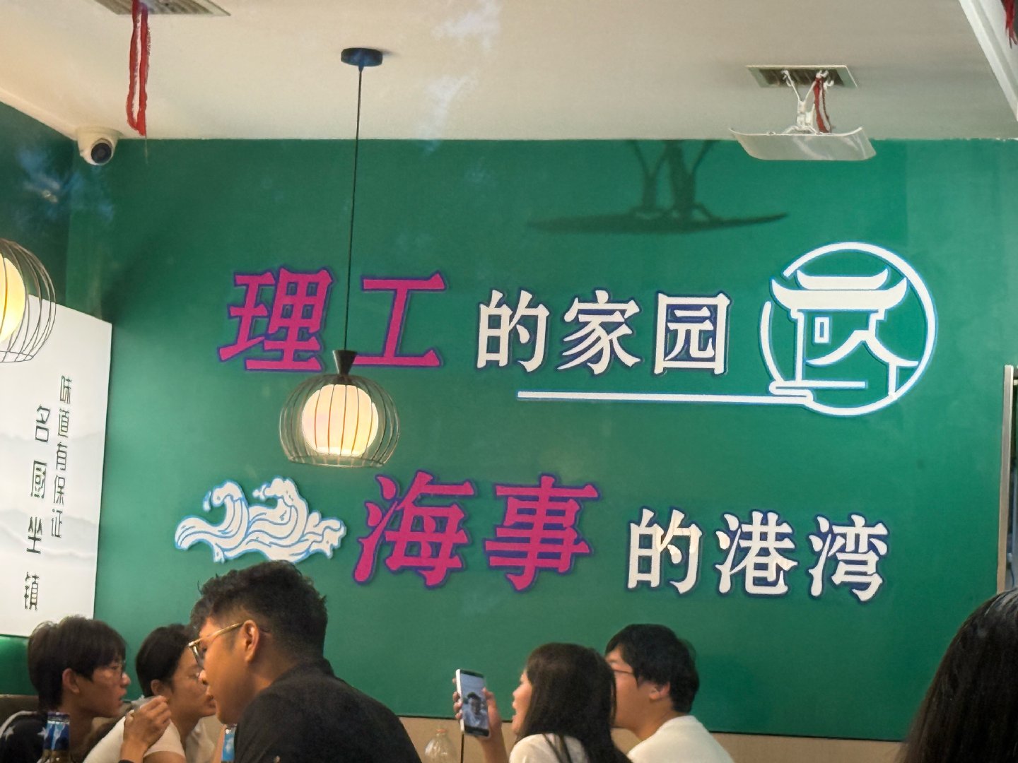 我在大连理工大学旁边的烧烤店。旁边一个男生一个女生，男生喝饮料，女生喝乌苏，已经