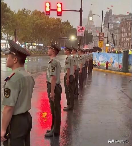 9月13日傍晚，上海突降暴雨，在南京路外滩值勤的军人笔直地站在暴雨中，路人纷纷站