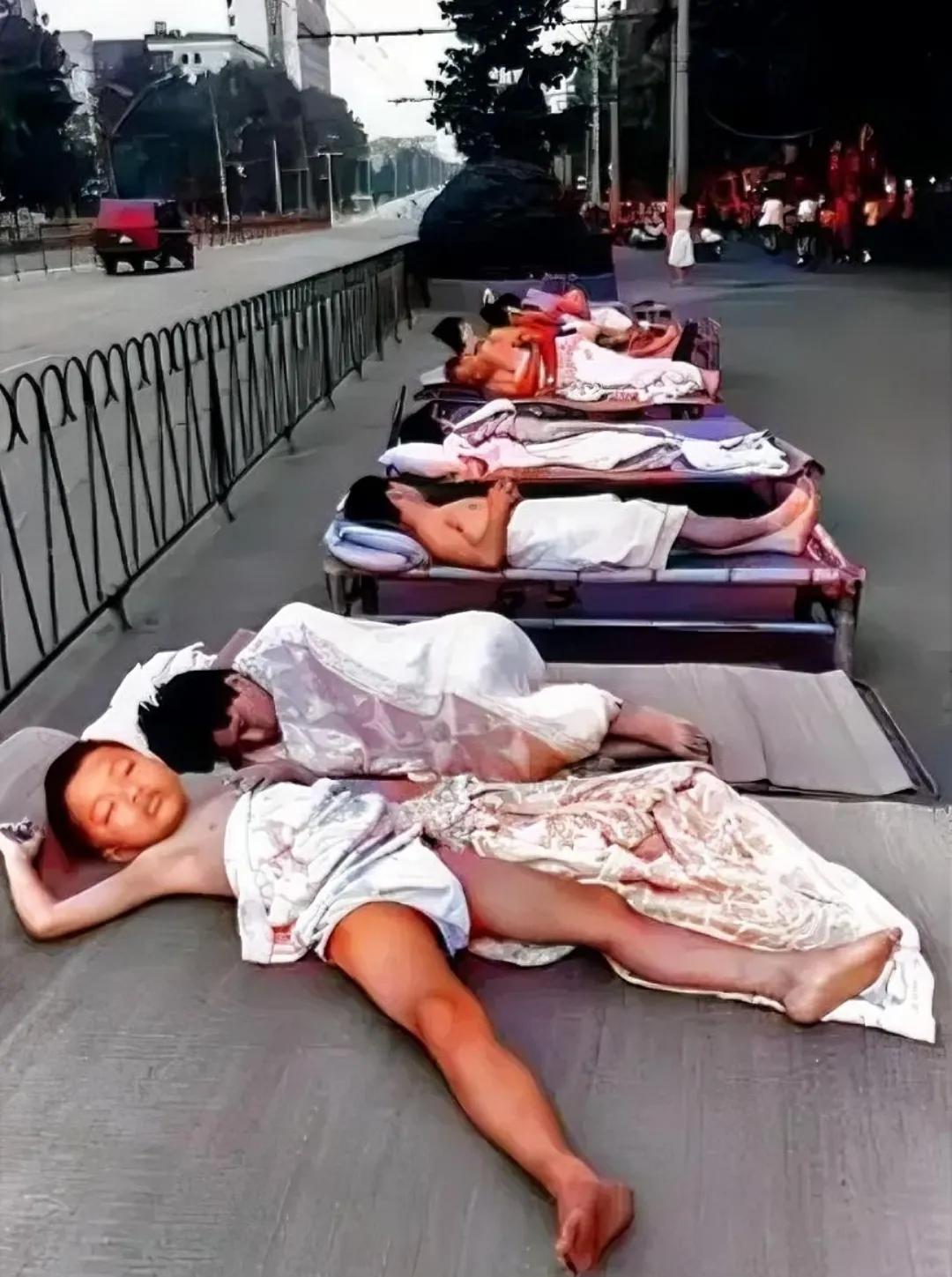 1990年夏季，武汉街头，市民们自带铺盖到马路边上打地铺，留下的镜头，尽管已经破