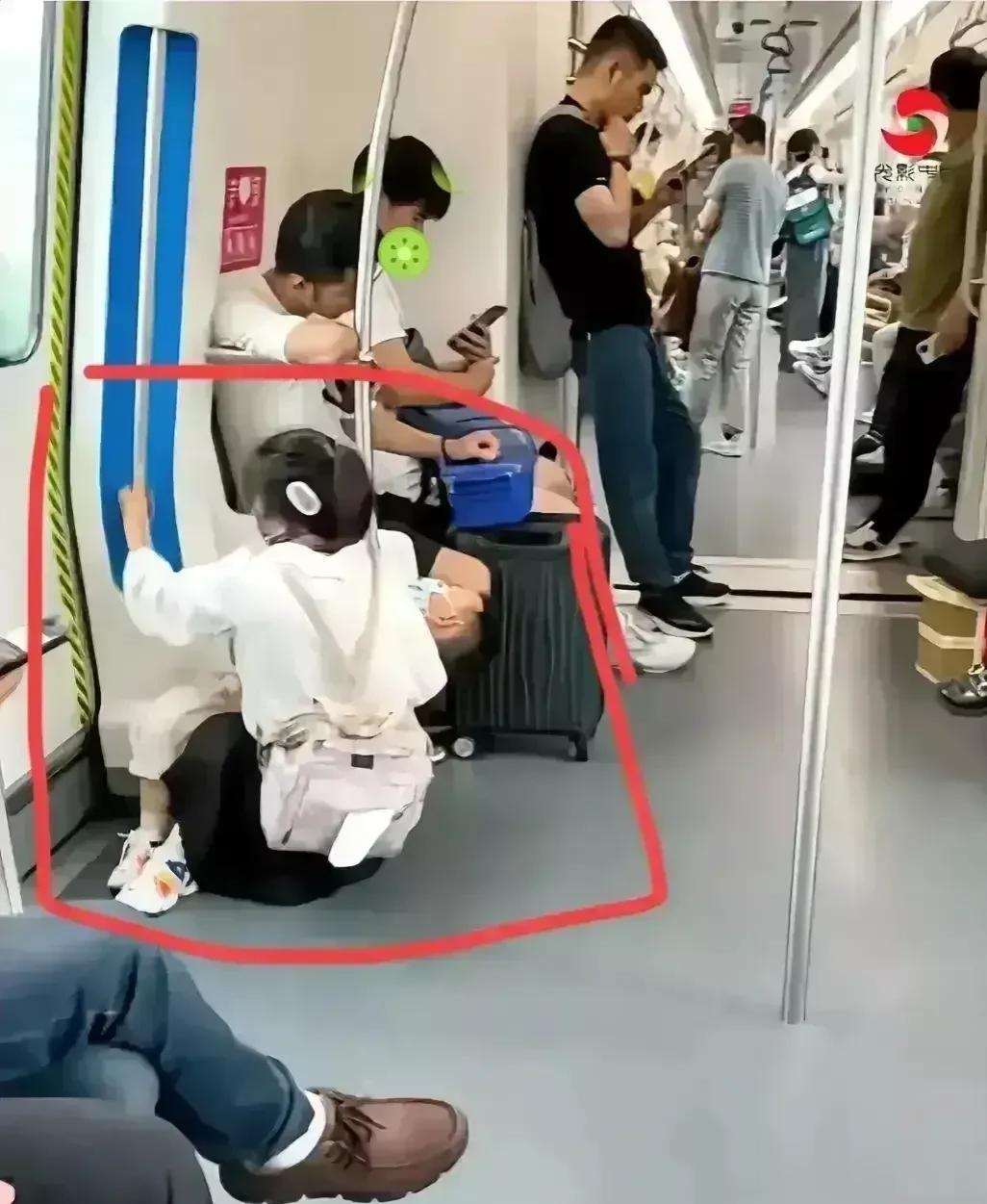 一位年轻妇女抱着孩子上了地铁，车上坐满了人， 有的人闭目养神，有的人拿出手机看着