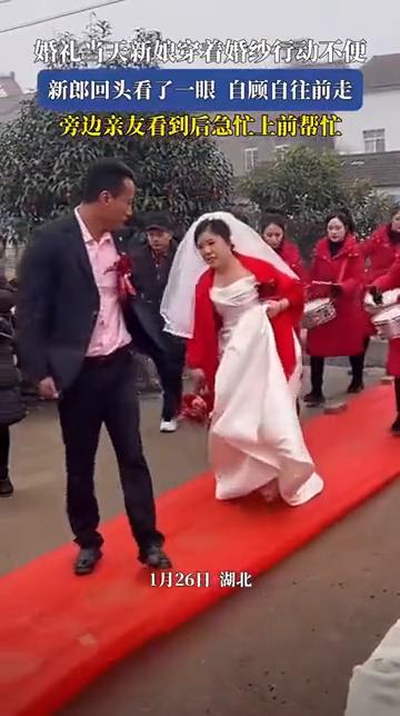婚礼当天新娘穿着婚纱行动不便，新郎回头看了一眼自顾自往前走，旁边亲友看到后急忙上