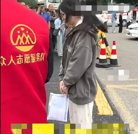 6月7日，河南商丘，一女生高考进场前转身向母亲三鞠躬，妈妈举着“一举夺魁”的向日