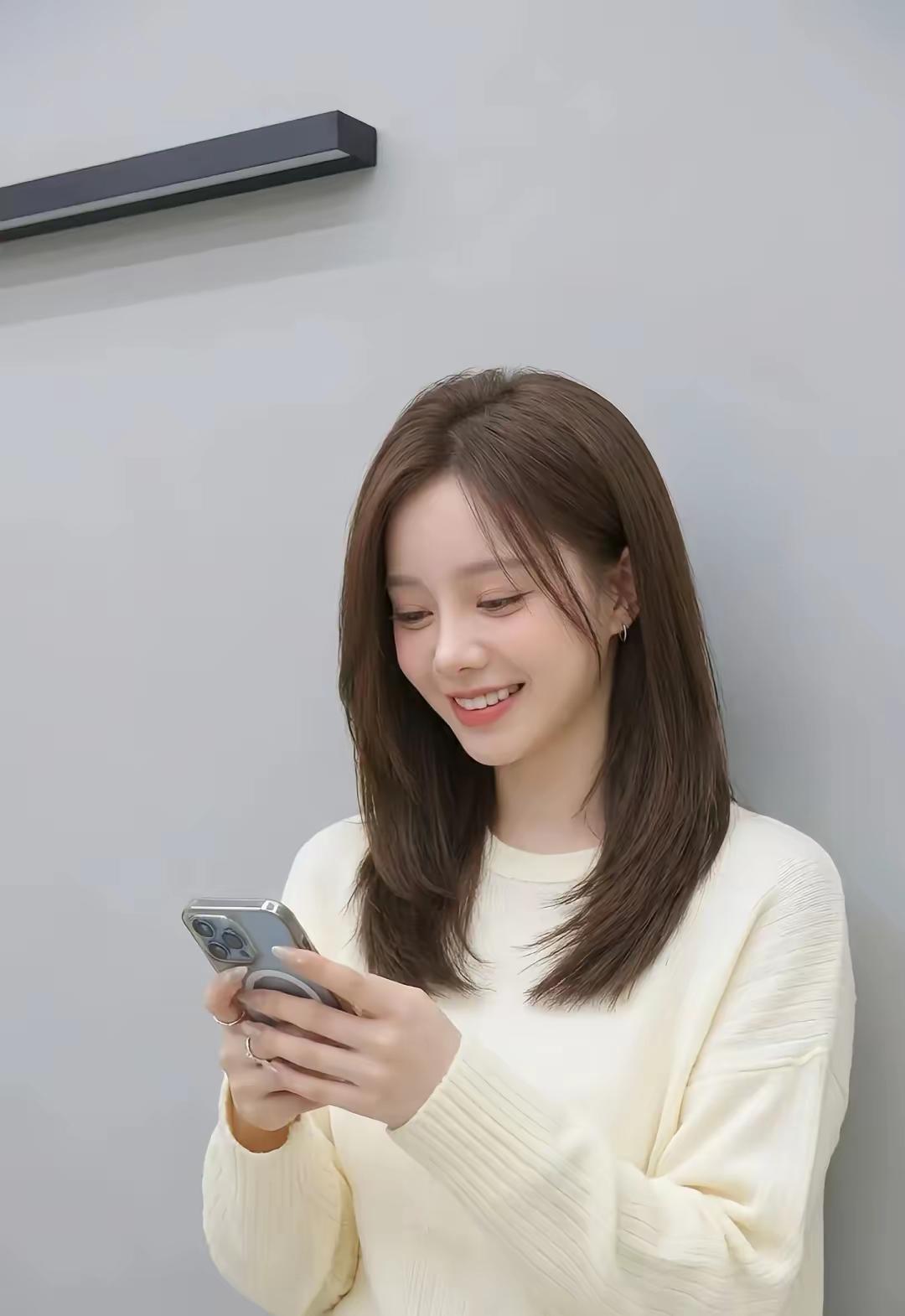 浅杏色针织衫衬得皮肤莹润，锁骨发的弧度温柔又灵动，抬眸时是清冷的甜，低头笑时又软