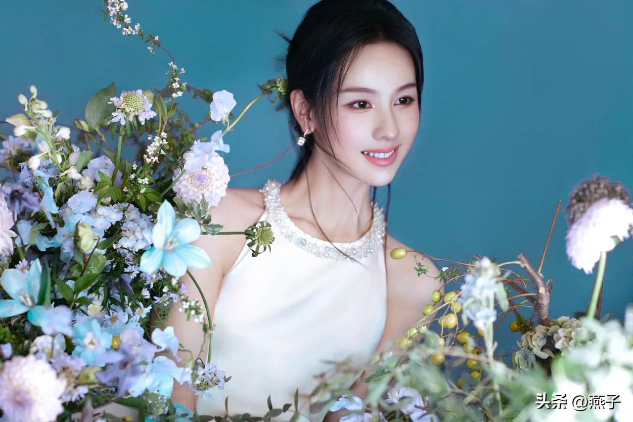 陈都灵她身着一袭白色挂脖长裙写真美出高级感，宛如花丛中盛开的白玫瑰🌹高贵纯洁于
