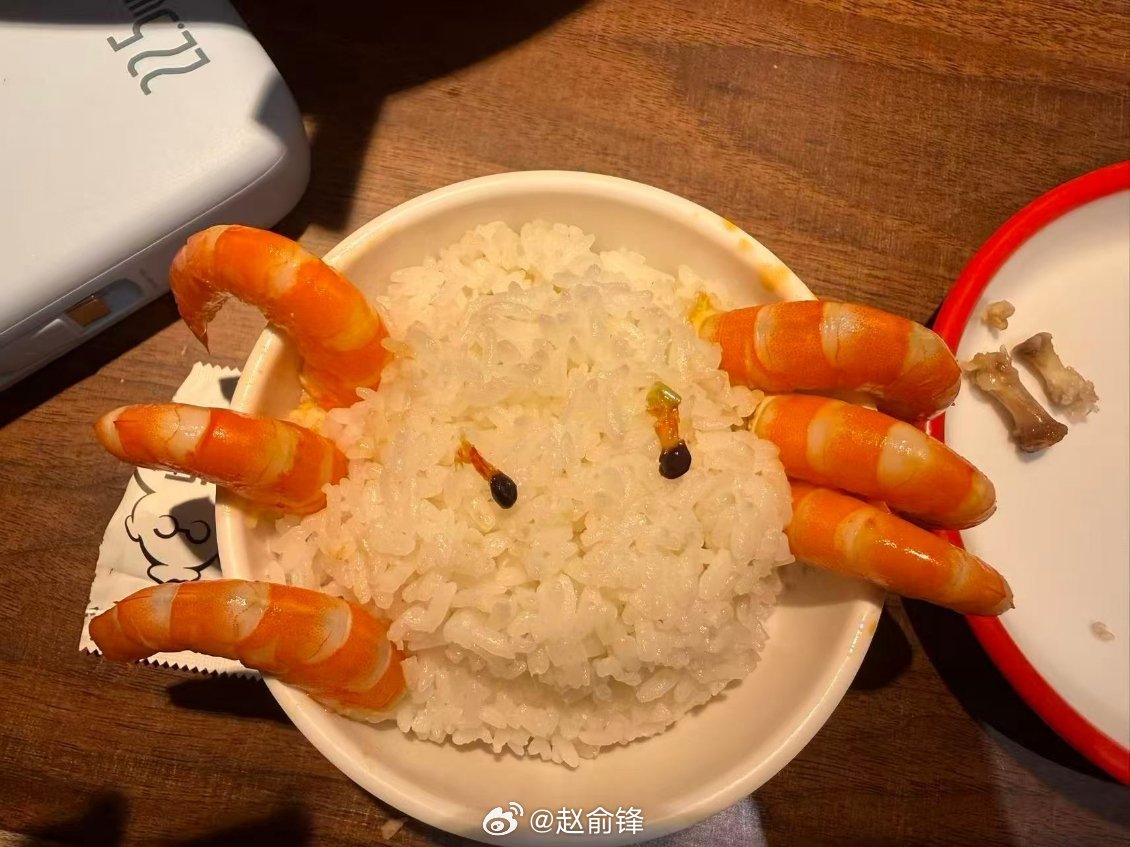 白米饭捏成圆形脸蛋，熟橙红大虾拆分摆放：上方三只虾尾当作鹿角，下方三只虾尾充当胡
