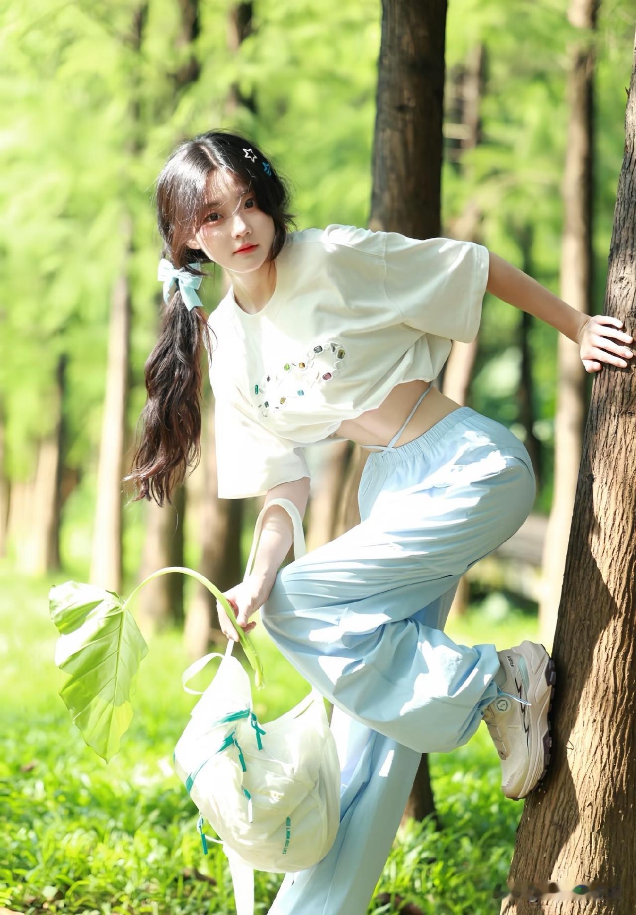 一个女孩在树边拍照，很可爱。