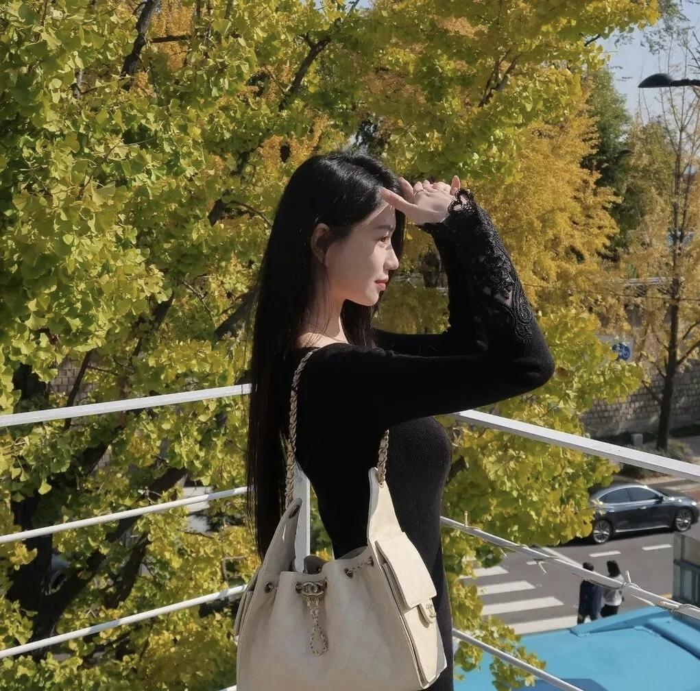 阳光穿过满树金黄的银杏叶，在黑色针织衫上落下细碎光斑。今日份的松弛感，是街角的秋