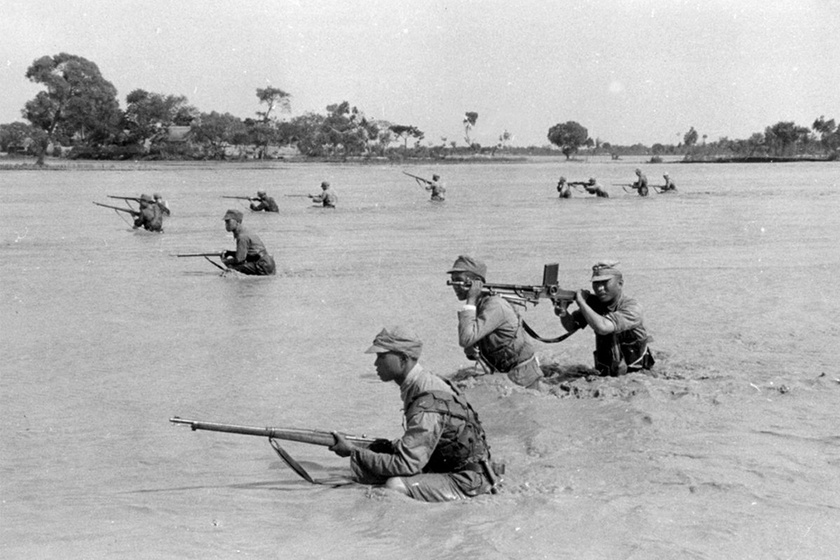 1938年，黄河花园口决堤后在洪水中行进的中国士兵。 
