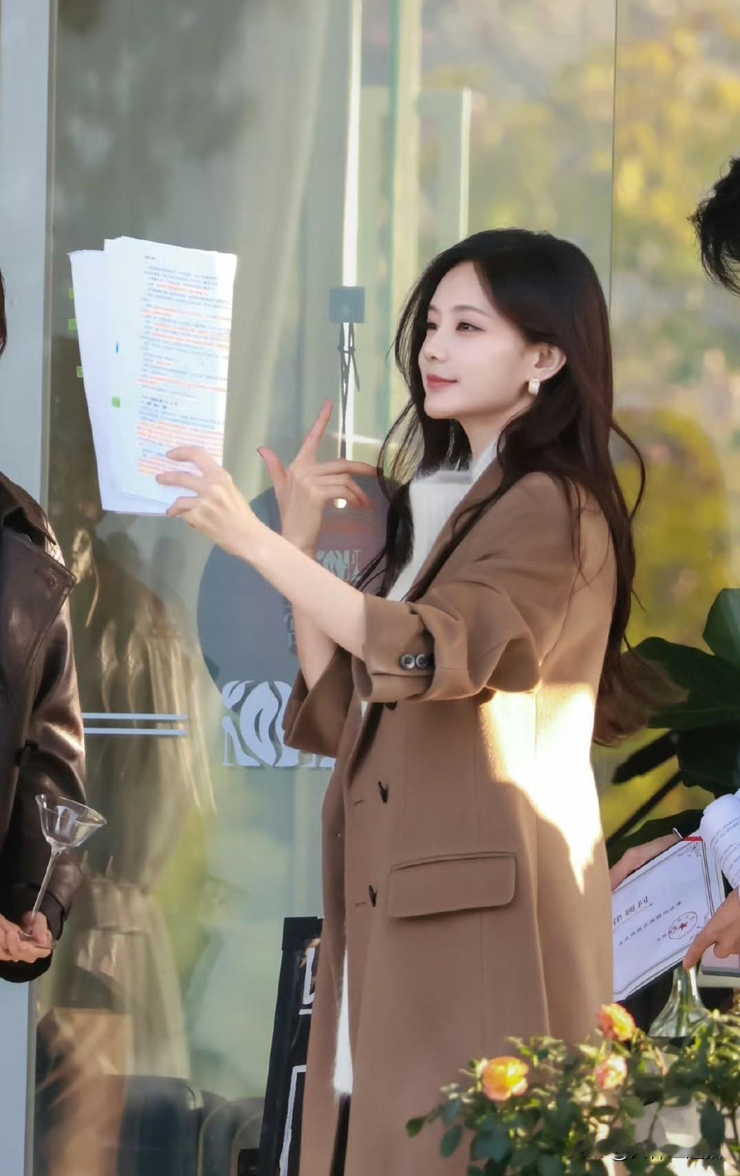 一位女士拿着文件，微笑着展示。