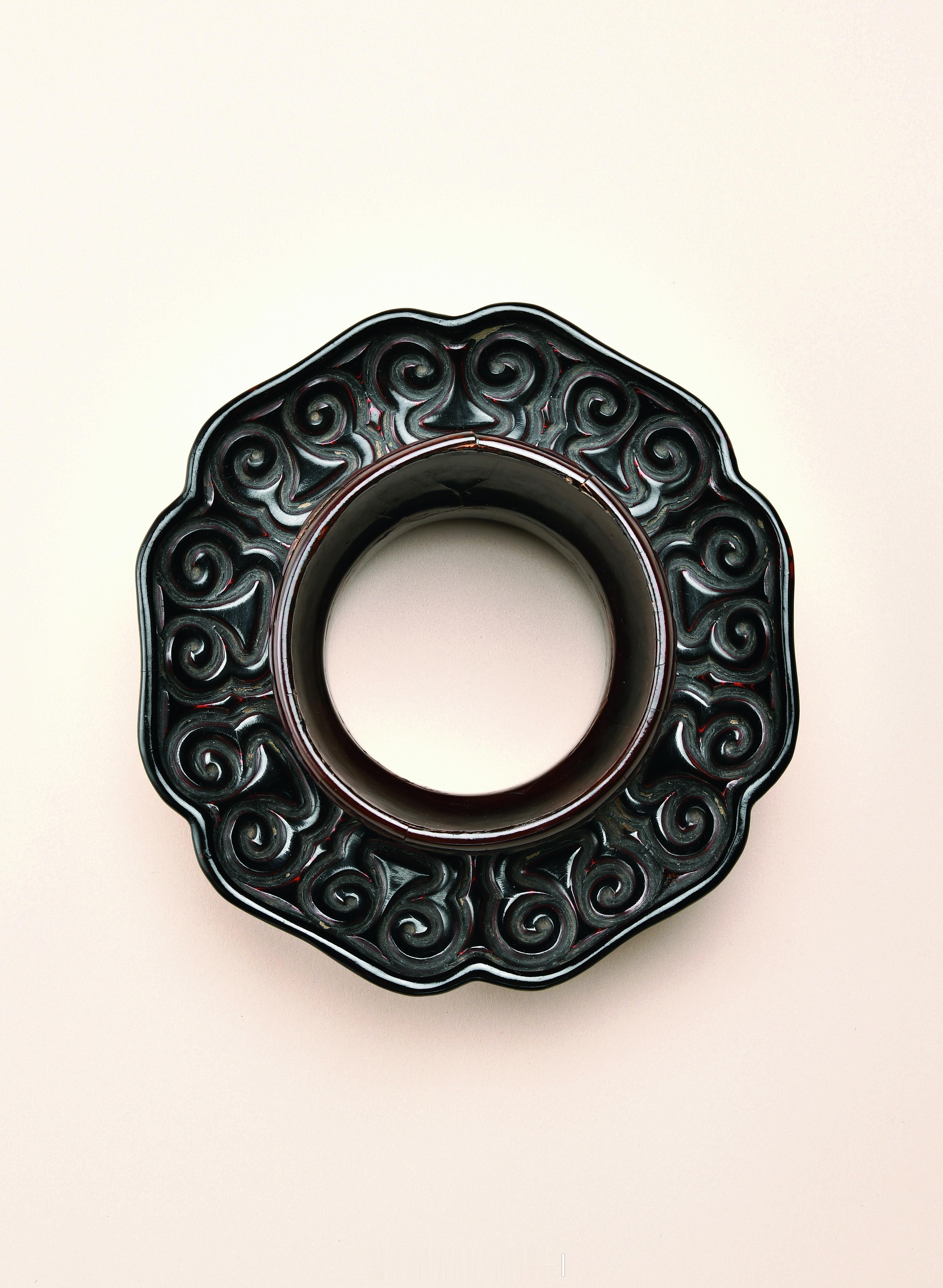 髹饰录 | 明 剔犀如意云纹盏托盏托以木为胎，经旋制髹饰黑色大漆剔雕而成，整体由