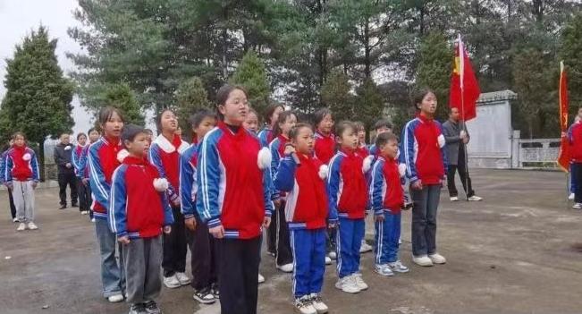 2026面3月底上午，贵州大方县八堡红军坟，一群孩子面对烈士墓碑，热泪盈眶高唱国