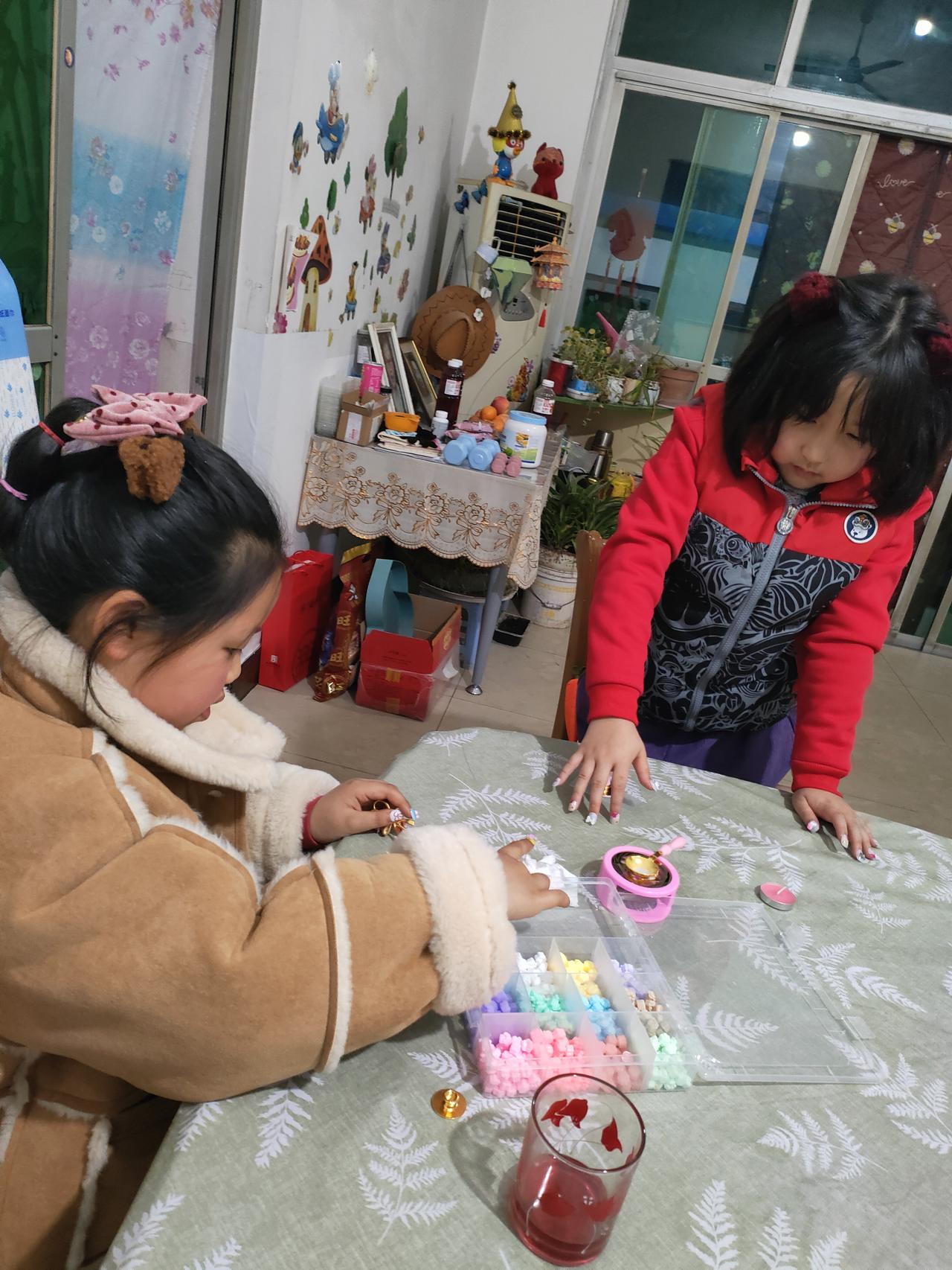 晒图笔记大赛两个小姐妹凑在桌前，用彩色串珠和小玩具编织着属于她们的小世界。窗外夜