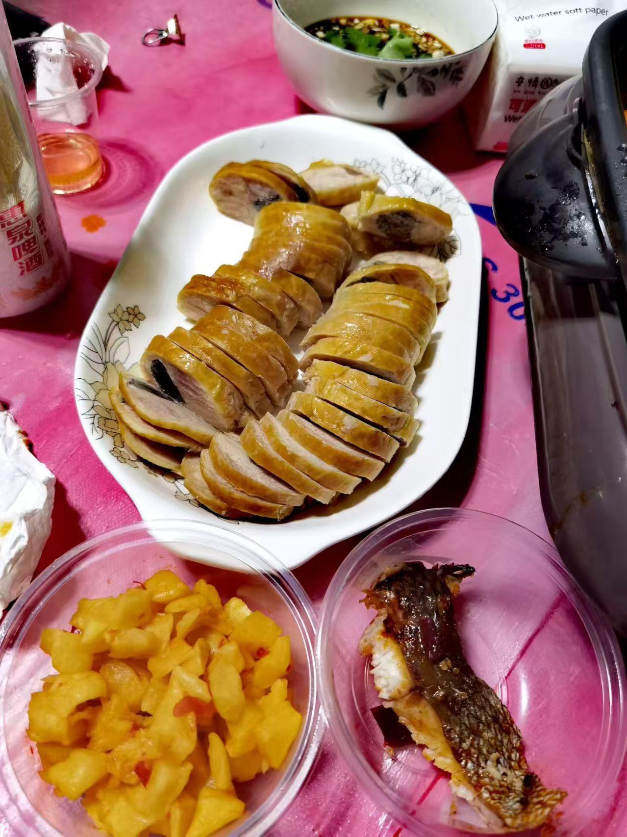 这桌菜真丰盛，有烤鸭和水果。