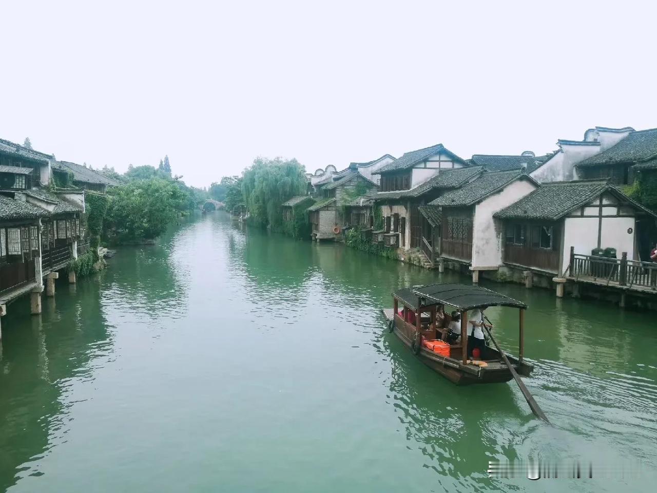 当踏过青石板路
看灰墙黛瓦民居
走过纵横交错水巷
迎晨曦送晚霞
我再一次来到乌镇