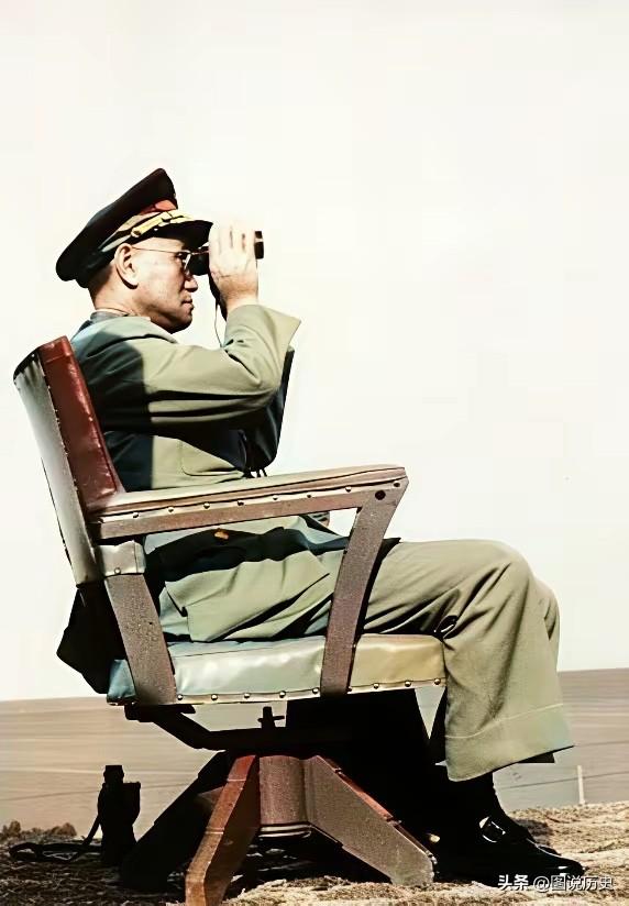 这张珍贵老照片拍摄于1967年，在海对岸一位80岁的老人独坐藤椅上，他用望远镜在