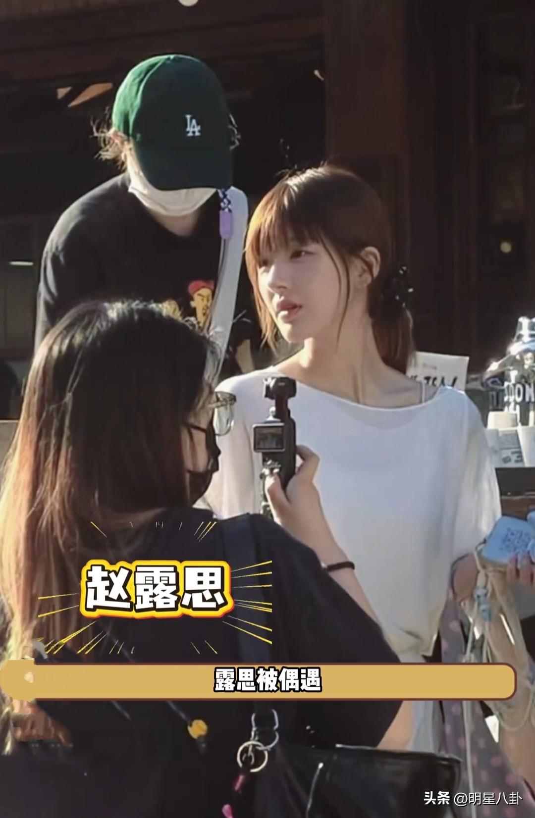 赵露思在韩国街边被偶遇，白色上衣短裙，简单的扎个马尾，在街边走过，抬手遮阳光，自