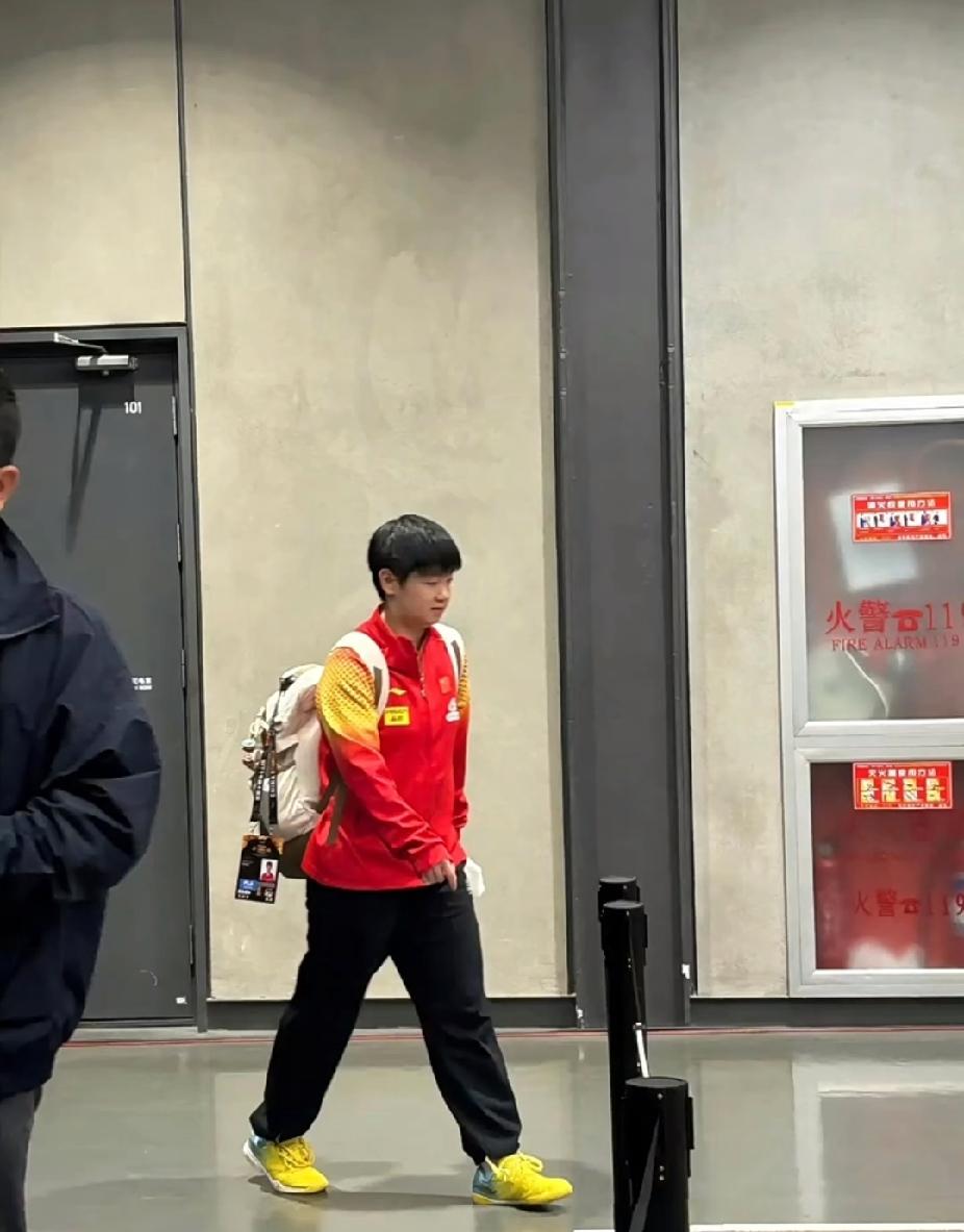 远远走来的莎莎，背着双肩包，包上还挂着可爱小挂件和门禁卡，一身队服，脚步轻轻的。