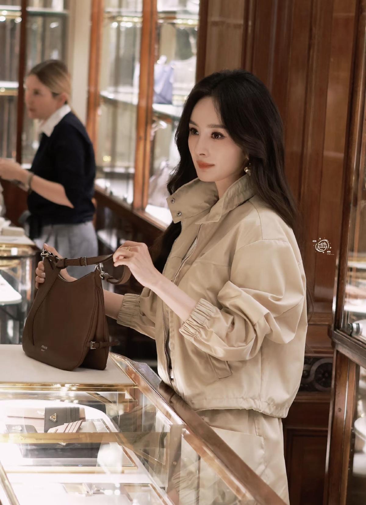 杨幂一套卡其色休闲套装，立领设计与松紧袖口兼具利落感与松弛感；搭配大波浪卷发与精