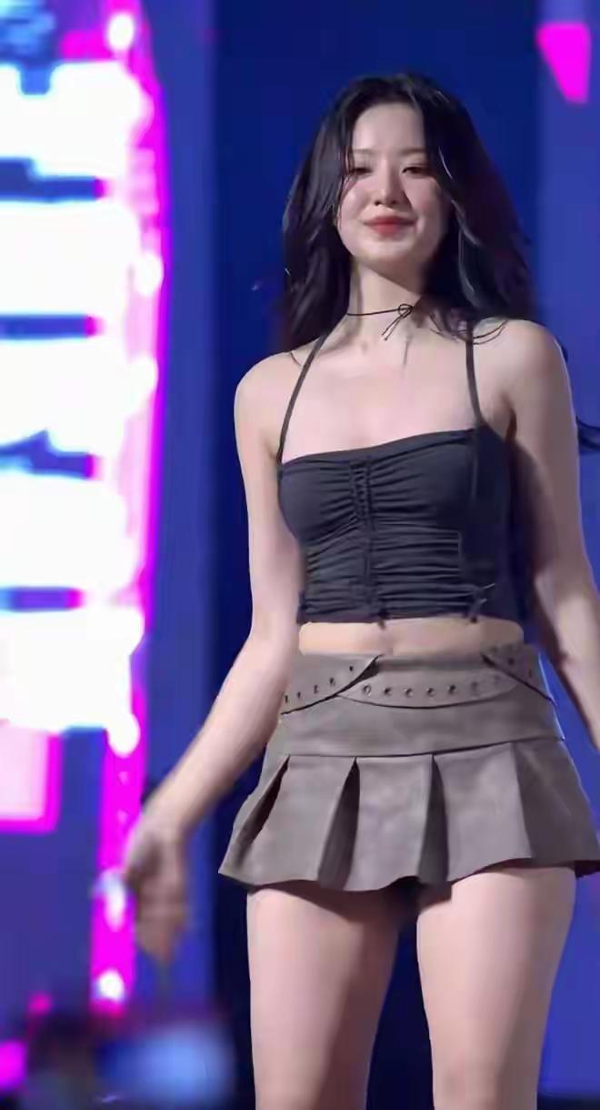 舞台上的甜美少女，黑色上衣搭配棕色短裙，自信微笑，光彩照人！💃🏻✨