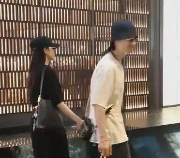 吴建豪与新婚妻子荒卷绘美在新加坡被路人撞见。二人牵手同行，女方气质飒爽五官出众，
